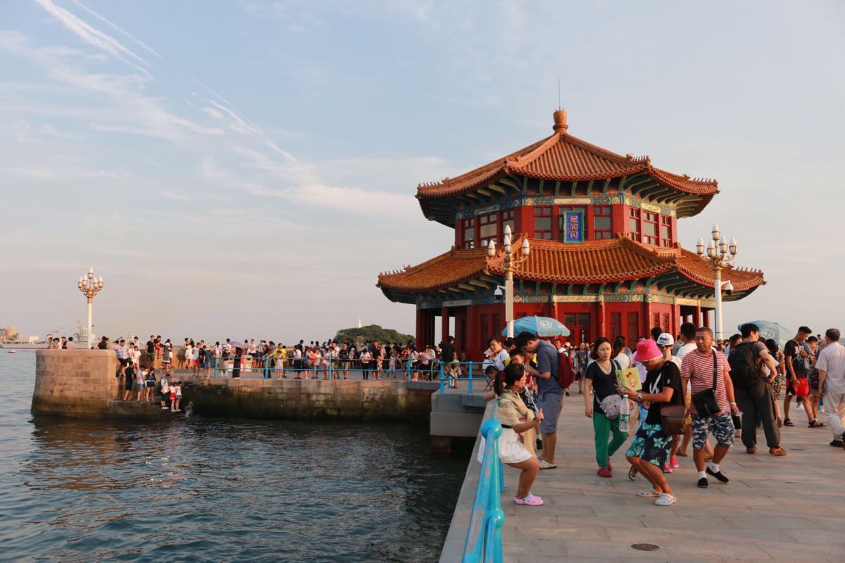栈桥是青岛海滨风景区内的一个标志性景点,与青岛市区繁华的商业街中山路相连,并直接伸入海中400多米,当海轮驶入青岛港时,首先应如眼帘的便是这座青岛的标志栈桥。 陆路进入由于景点免费,桥上经常人满为患。漫步栈桥之上,可尽收青岛湾的如画美景,簇簇雪白浪花、点点赤色礁岩,红瓦绿树点缀于海港之滨,飞阁回澜安坐于碧波之上,百年沧桑,终现生机勃勃。