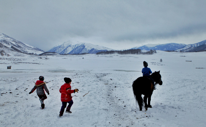哈萨克族小孩在雪地里嘻嘻,从小就会骑马的他们显得特别英飒!