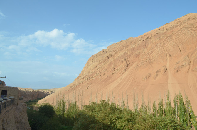 虽然四周荒山赤岭,寸草不生,但崖下一泓清泉,带来一片绿荫.