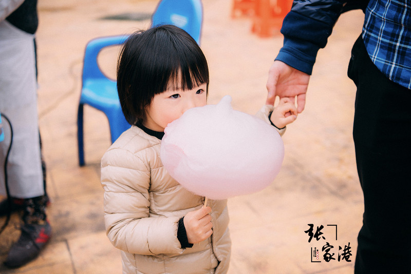 旁边的小姑娘舔着比她头还大的棉花糖,这专注的小眼神儿看起来十分