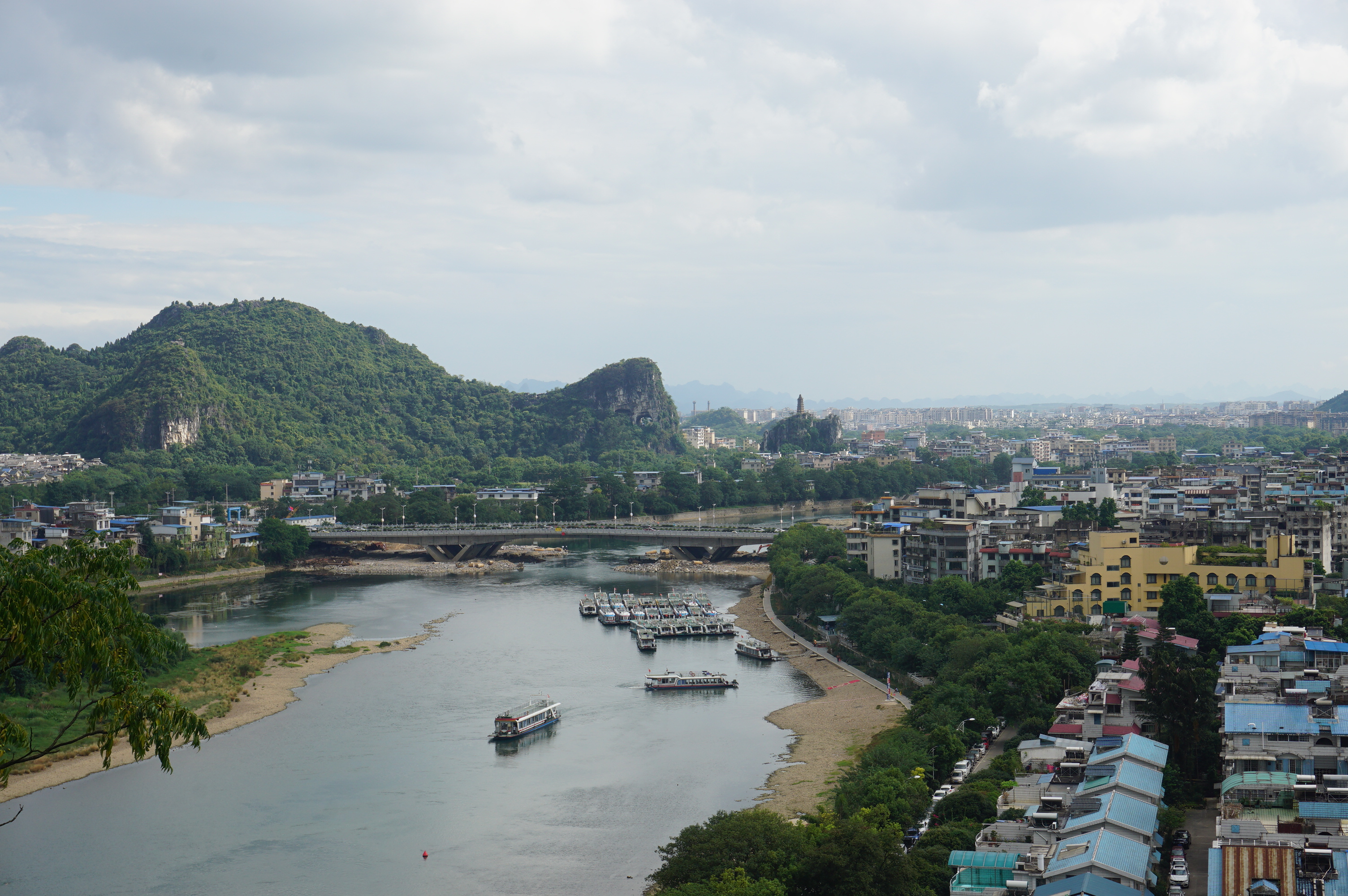 原名漓山,国家4A级景区,位于广西区桂林市内滨江路桃花江与漓江汇流处,山因酷似一只站在江边伸鼻豪饮漓江甘泉的巨象而得名,被人们称为桂林山水的象征。
象山以神奇著称,首先是形神毕似,其次是在鼻腿之间造就一轮临水明月,构成象山水月奇景。形似一头鼻子伸进漓江饮水的巨象,象鼻和象腿之间是面积约一百五十平米的圆洞,江水穿洞而过,如明月浮水。坐落西岸的象山水月与漓江东岸的穿月岩相对,一挂于天,一浮于水,形成漓江双月的奇特景观。
早在唐宋就成为著名游览胜地,有1000多年的游览史。
