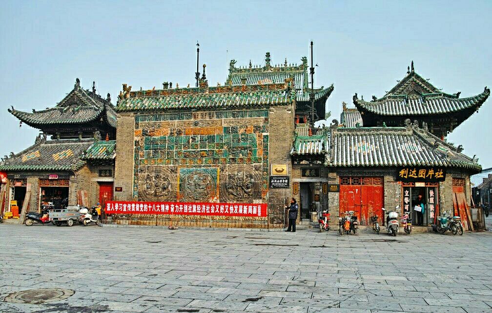 在赊店镇上一路走来,看到这个山陕会馆,本来不是很有兴趣,但想到既然来了还是进去看一下吧,结果让我很是惊艳。
门口看起来真的感觉不到什么,只有一个一面琉璃照壁,这里位于社旗县城中心,在过去这里水陆交通非常发达,是南船北马商人的云集之地,这里还有七十二行祖师堂,看起来很有气势。
赊店镇是南北九省过往要道和货物集散地,有街72条。进入会馆后从一进门的悬鉴楼、石牌坊、大拜殿和春秋楼,依次排列,两边旗杆、石狮、马厩、钟楼、鼓楼、廊房、马王殿、药王殿左右对称,主次分明。