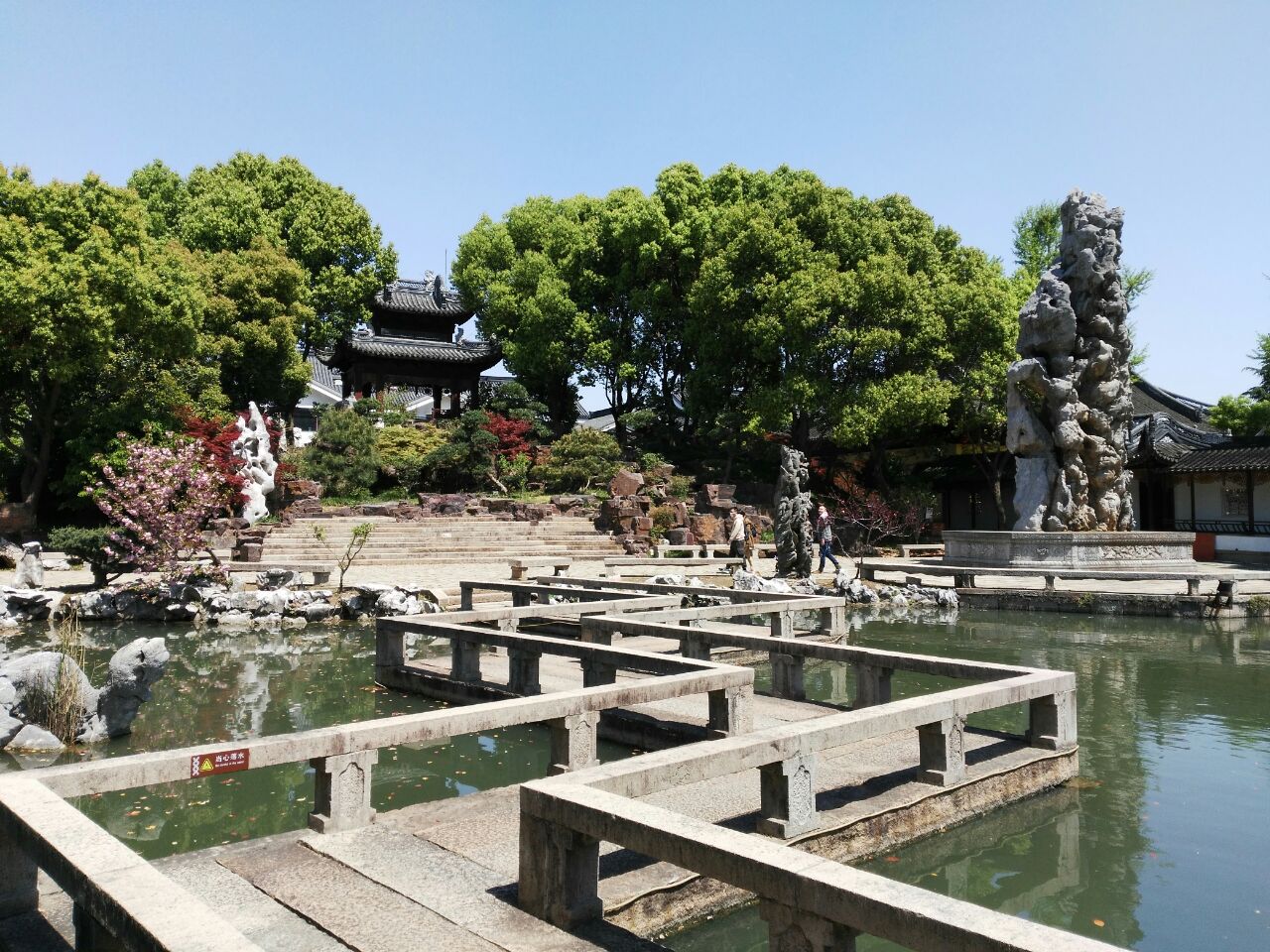 年十月十五翌日,适逢网站传吴江之地,选定静思园为其一,余幸遇前往观之,窃喜,欣然入园。
富而思文,静而致远乃陈金根取园名之因,坐落于苏州偏郊之地,闹中取静,竟显园林之秀,廊桥之曲,怪石之奇,细宅之精,溪水之潺。
过壁墙,遂暝,顿息,睁目,豁然开朗,一石赫然耸视,名曰庆云峰,高约9.
