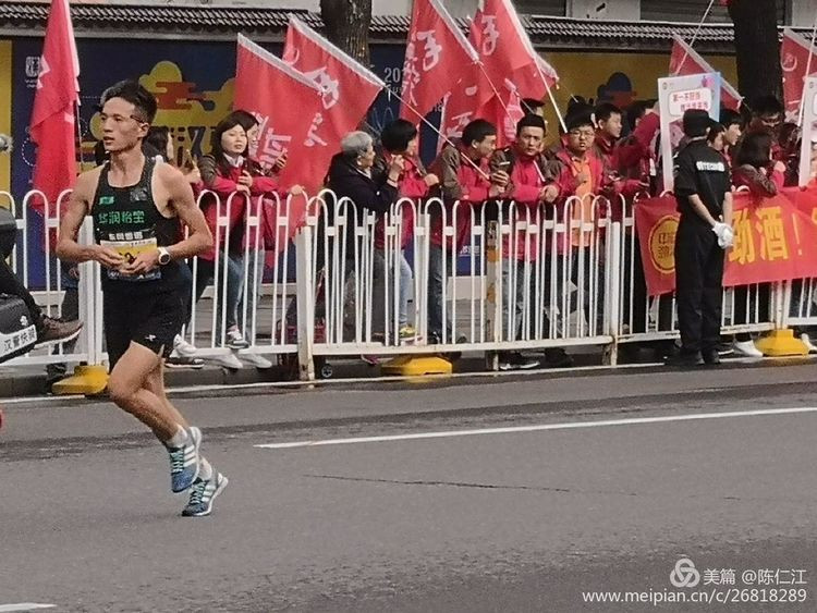 中外马拉松运动员们跑过来了!马路两边响起了加油加油的喊声.