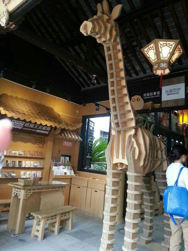 紙箱王創意園在周莊外圍,估計也是進入周莊景區的第一個景點啦!紙箱王的門市、餐飲部分主要有紙箱故事館、故事餐廳、蜜蜂故事館組成。紙箱故事館出售富有創意的紙藝品,比如紙燈、風車、紙模型,還有文具用品,價格小貴。故事餐廳提供周莊當地美食萬三蹄、阿婆菜等,也提供台灣美食,部分盛菜的餐具是紙做的。在戶外有露天座位,不時有歌手駐唱助興,小朋友還可以付費坐小火車玩。蜜蜂故事館出售蜂蜜制品,紙做的展示櫃呈蜂巢的形狀。