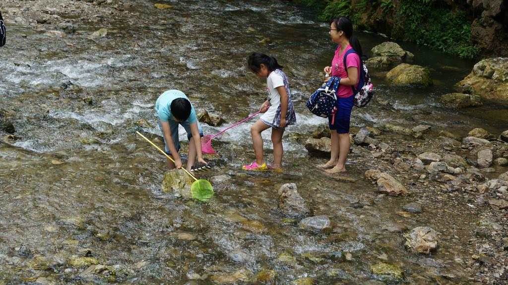 喜欢玩水的孩子泼水嬉戏着,与清澈的溪河来个亲密接触.