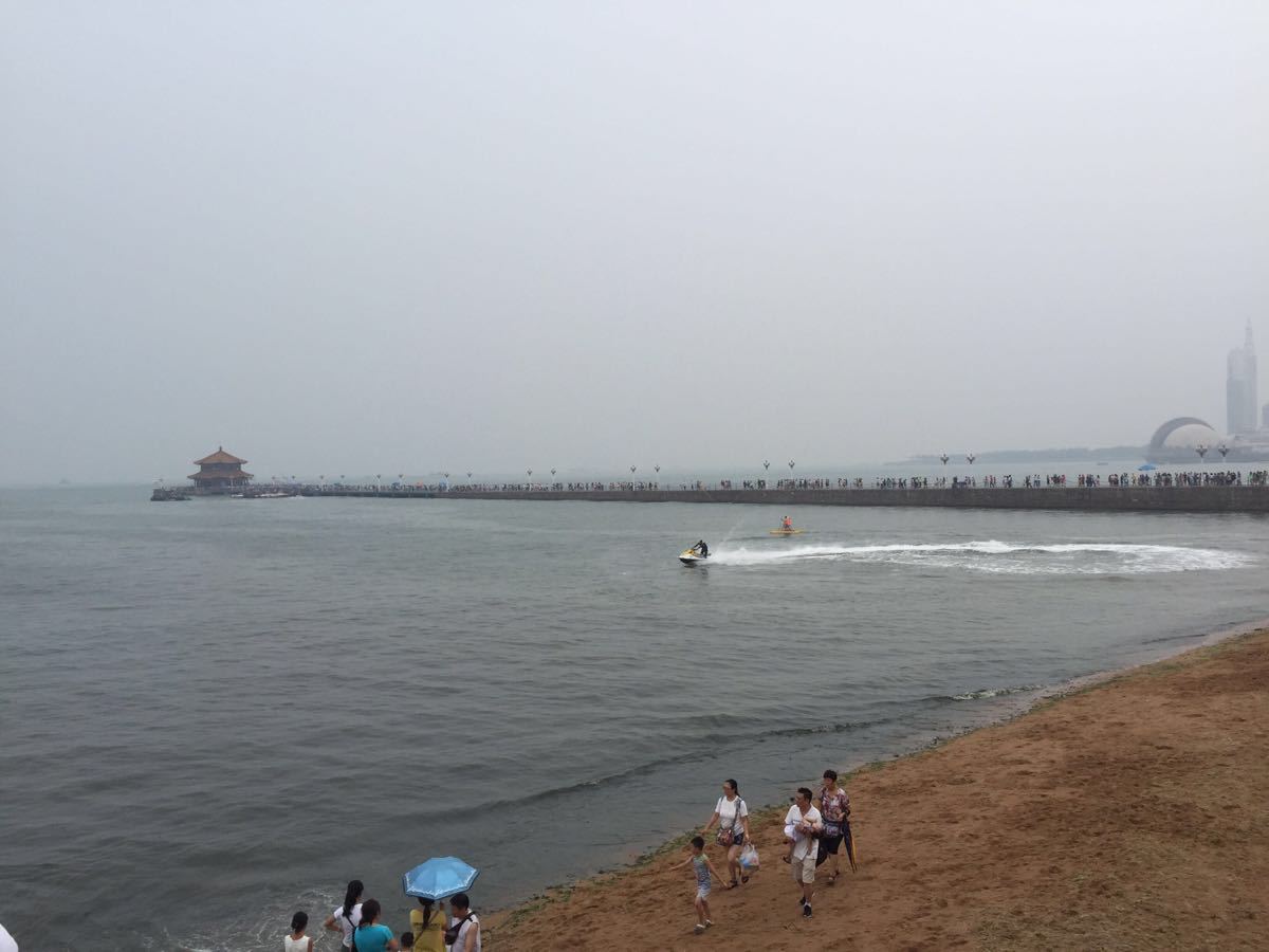 栈桥,位于山东省胶东半岛的海滨之城青岛市!火车站出门便可到达栈桥。很多公交车直接通达栈桥,交通的便捷度几乎毫无悬念! 沿着栈桥步行,简直就是一种享受呀! 蓝色的天空、红色的砖瓦房子、现代化的高楼大厦、碧蓝的大海。这些景物无不充斥着浪漫与欢快的情感元素! 沿着大海走一圈,真心的说很值得。 在这里,有很多众生解暑的天然免费浴场、有异国风光的欧式建筑的房屋、有成双成对的情侣在这里见证爱情的神圣与浪漫、有红色的石头与蓝色的大海组合成的画卷、有夕阳西下美、有小资般节奏的生活意味! 在这里我亲自感受到了夕阳与大海的