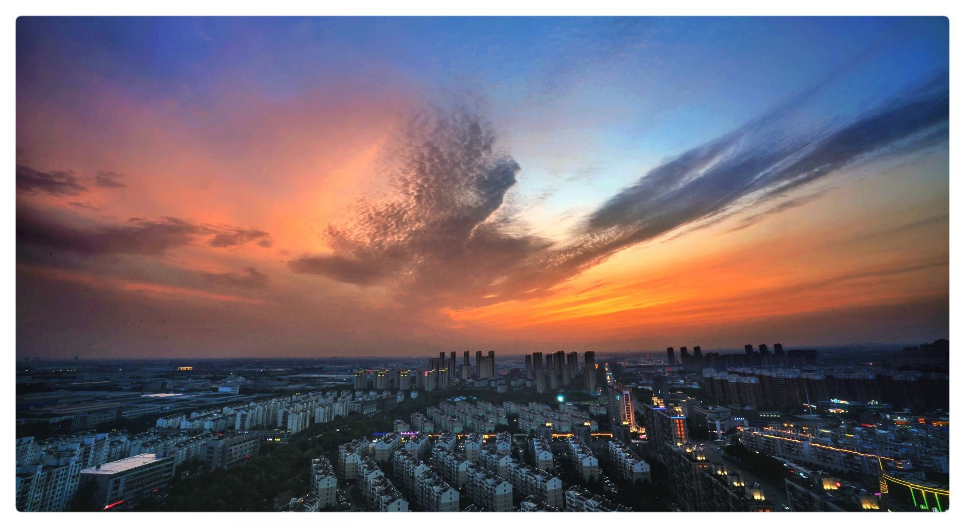 晚霞中的常州城,天空是静谧而厚重的深蓝,大地被镀上一层金色,水中的