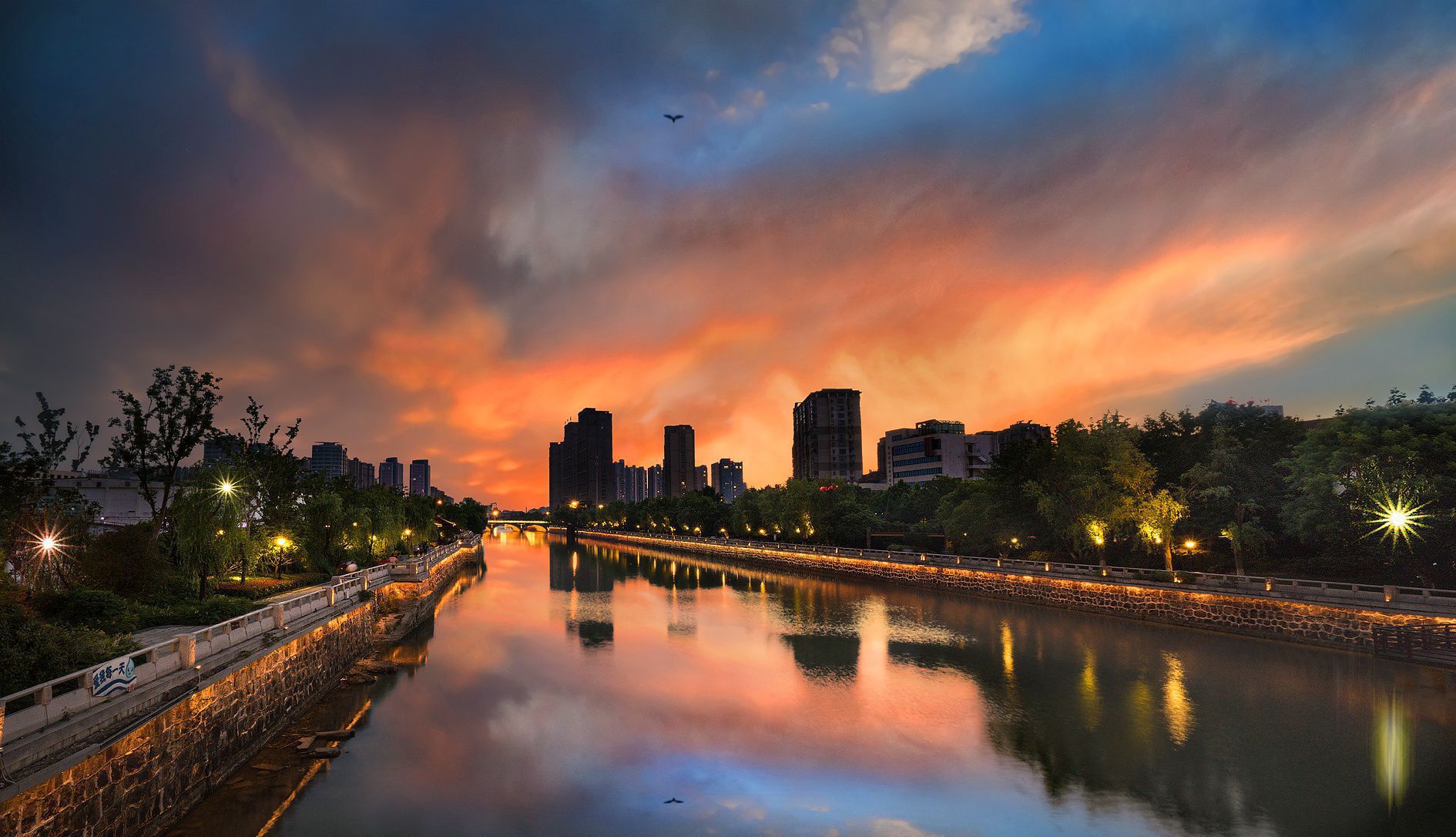 晚霞中的常州城,天空是静谧而厚重的深蓝,大地被镀上一层金色,水中的
