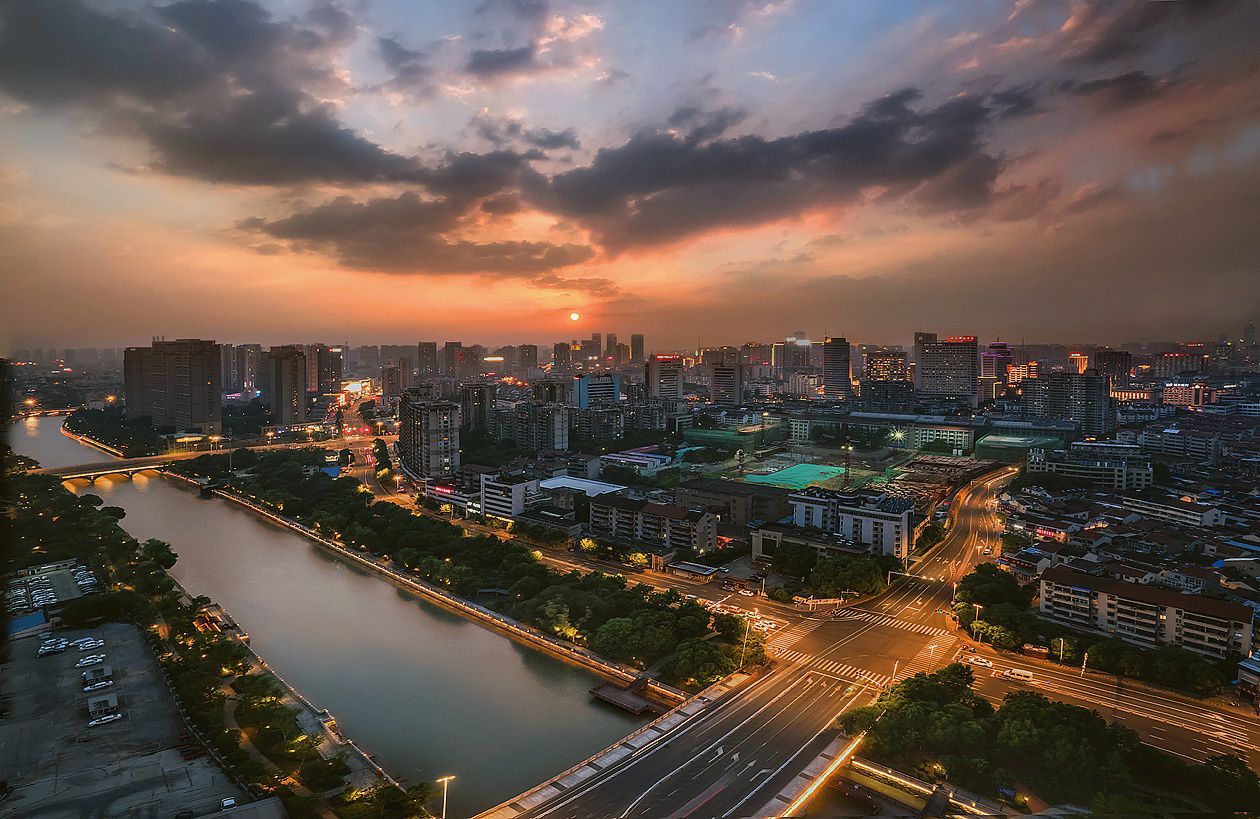 晚霞中的常州城,天空是静谧而厚重的深蓝,大地被镀上一层金色,水中的