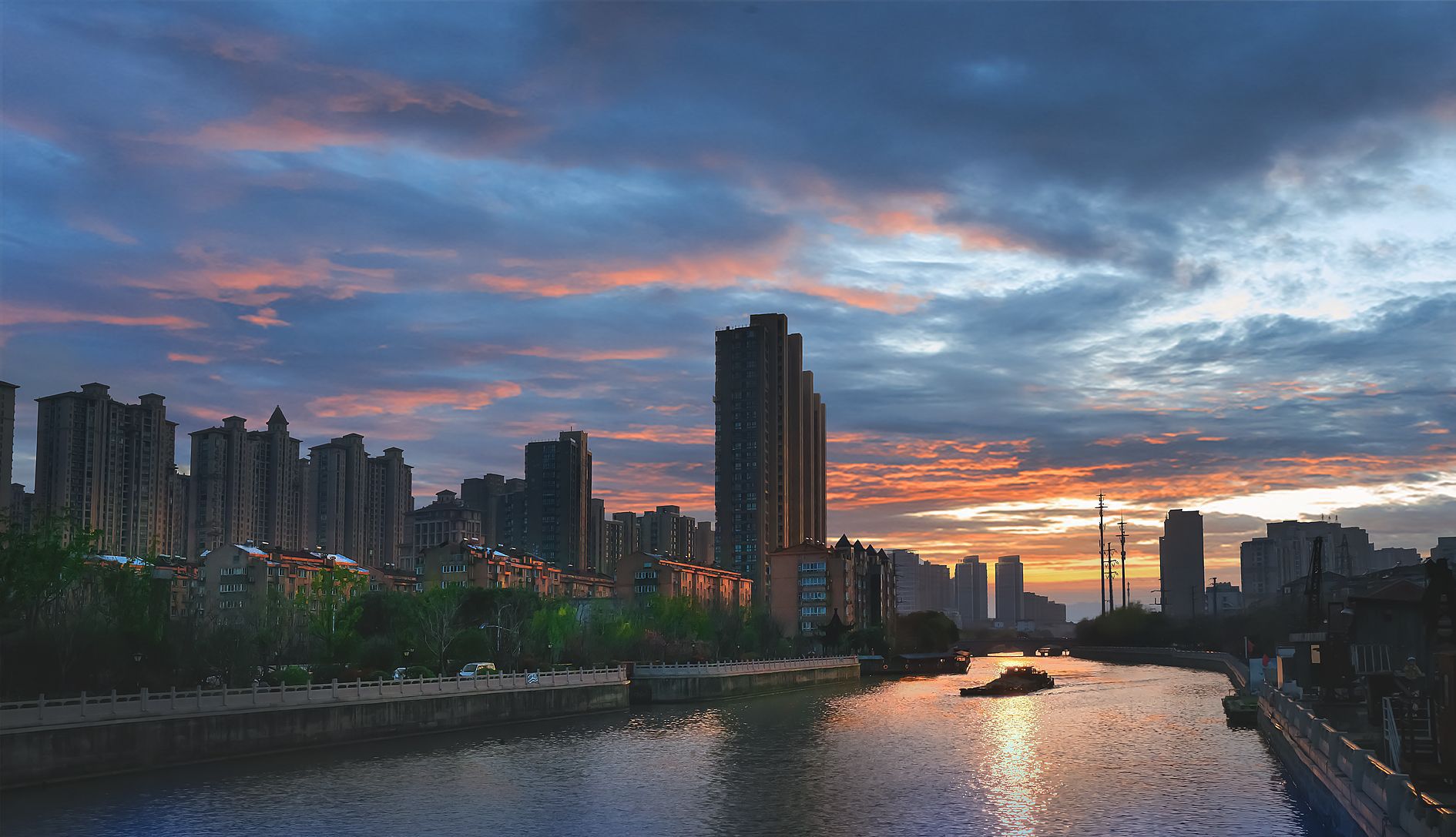 晚霞中的常州城,天空是静谧而厚重的深蓝,大地被镀上一层金色,水中的