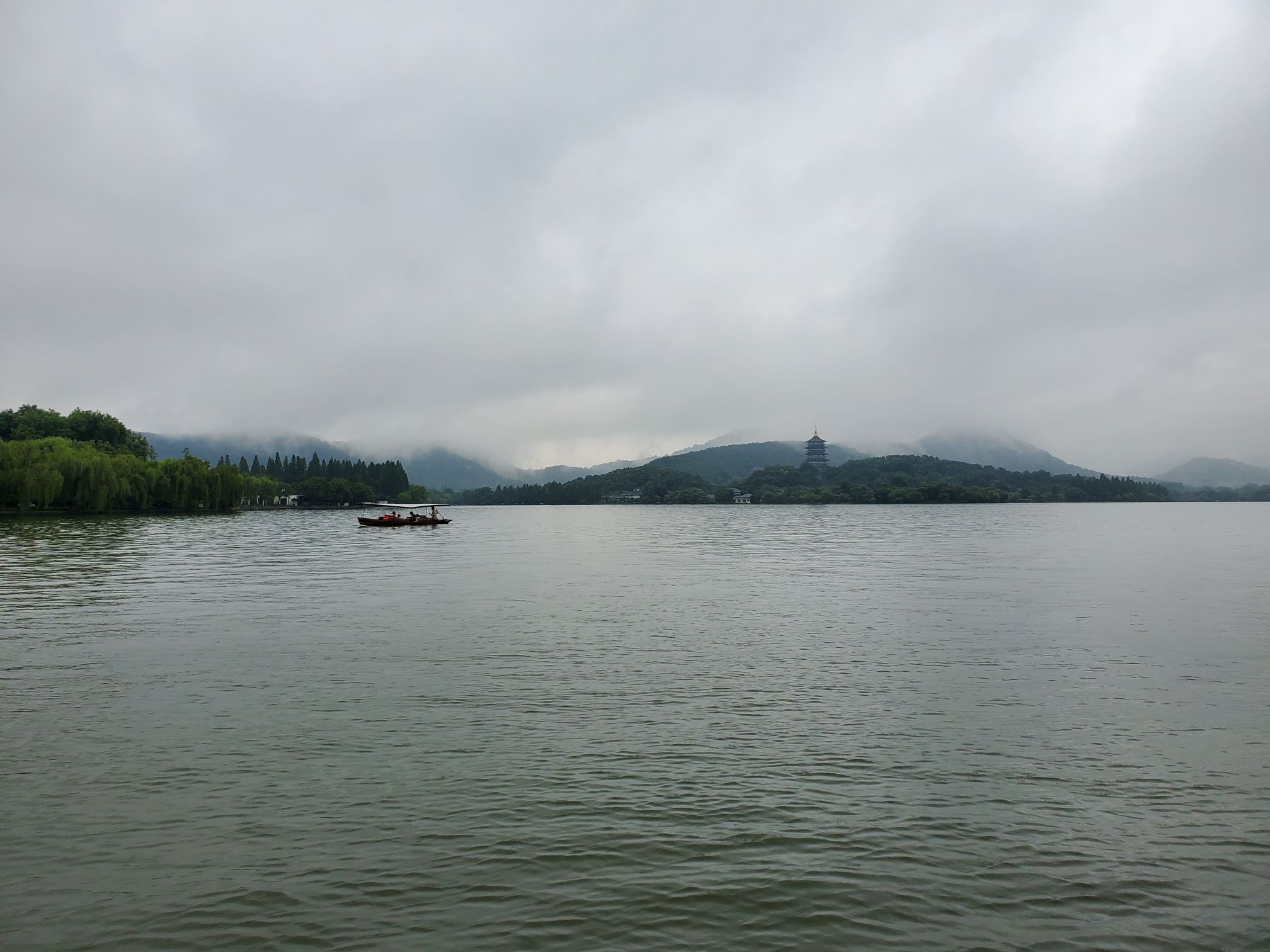 下着小雨的时候坐船游西湖景色真的是美不胜收,近边湖水余波荡漾,远山