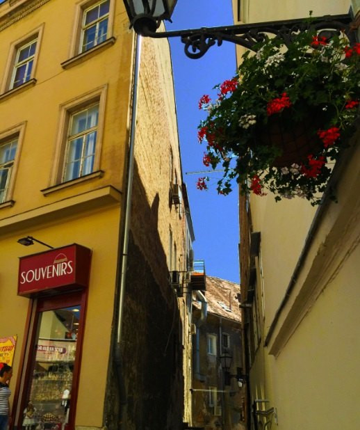 墙角处身着礼服,手打遮阳伞的女士画像是如此优雅逼真,不细看还真以为