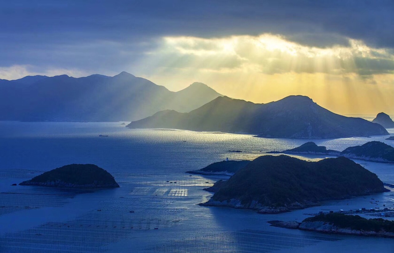 近景浮標竹竿,中景魚排木屋,遠景島嶼帆影,整個場景井然有序.