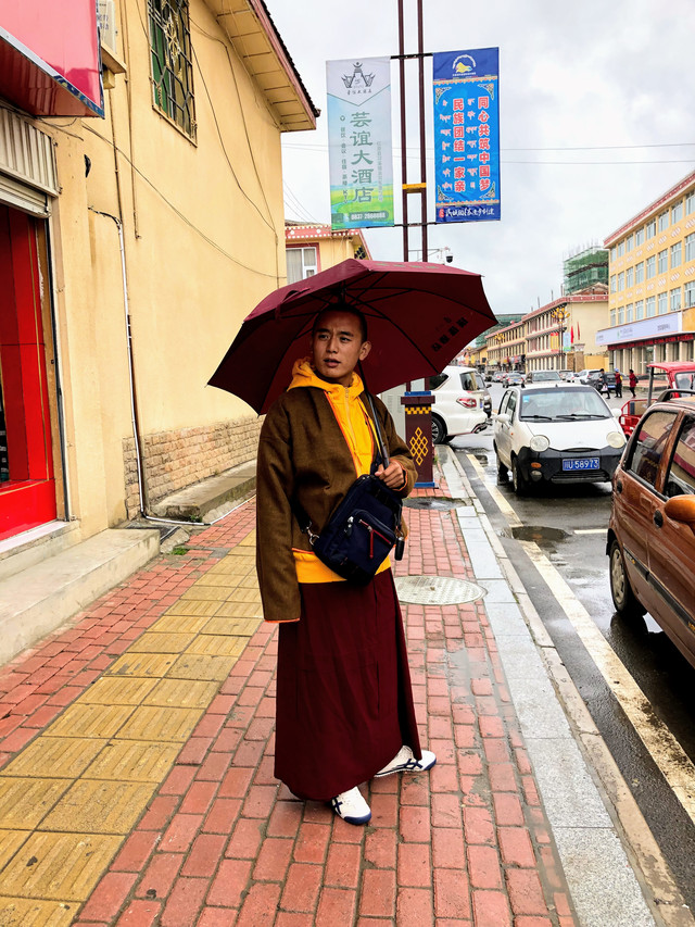 小活佛在大街上買了一件黃色的連帽運動衫,當場套上,因紅原變冷了.