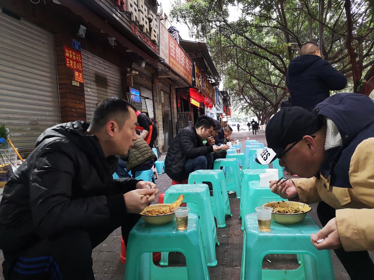重庆小面传说中的板凳面是一个高凳子,一个矮凳子,食客坐在矮凳子上吃