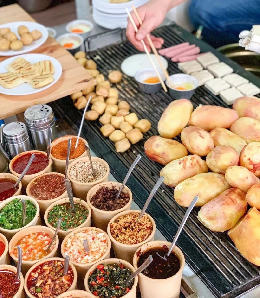 螺峰街上一家很火爆的烧洋芋店正宗泸西风味每天慕名来吃的人都很多