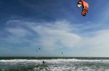 在越南南部美奈的海滩，这里海边的风浪非常大，海水也不是特别蓝，但是这里有非常多的老外在玩滑翔伞冲浪，
