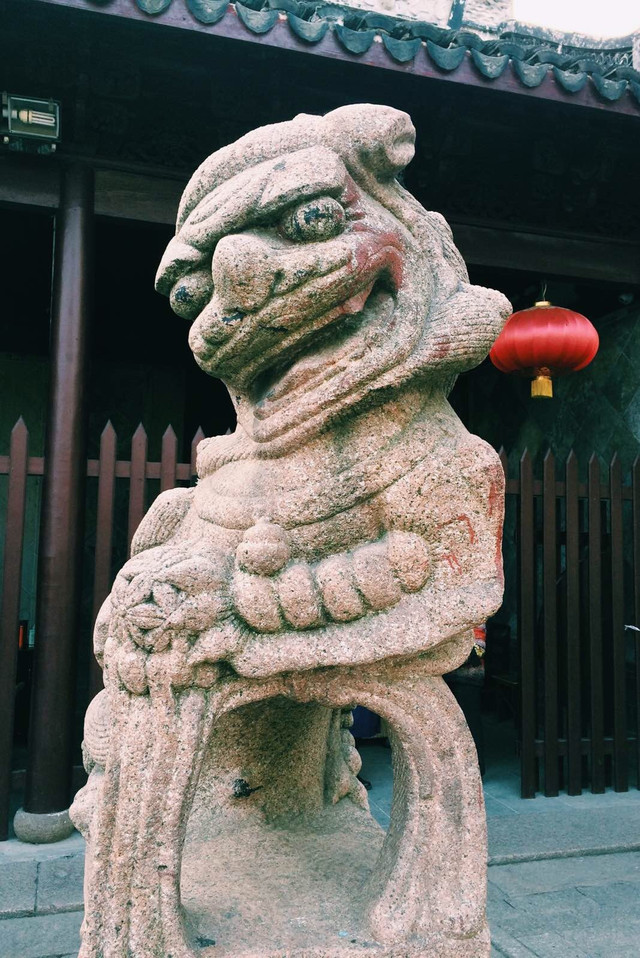 门口一对石狮的其中一只.不知道为什麽嘴边有红色的漆,好像涂了口红.